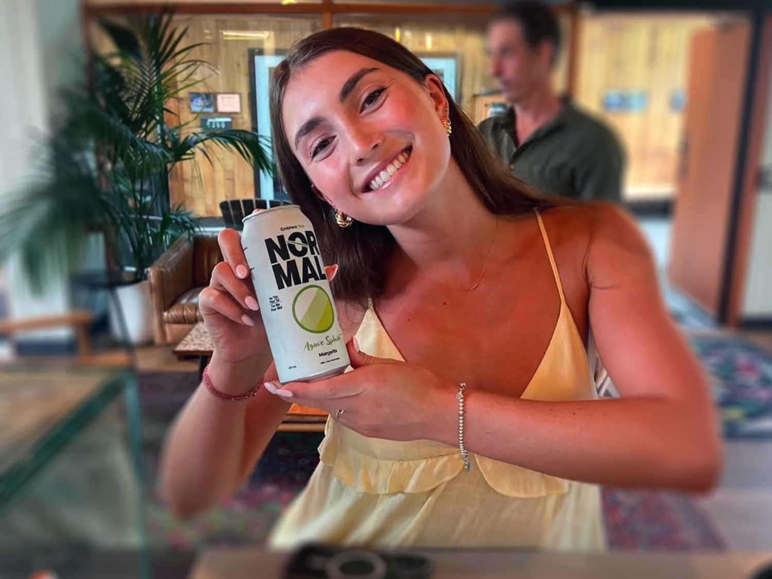 A young female holds a Normal Beverage Agave Splash Margarita can