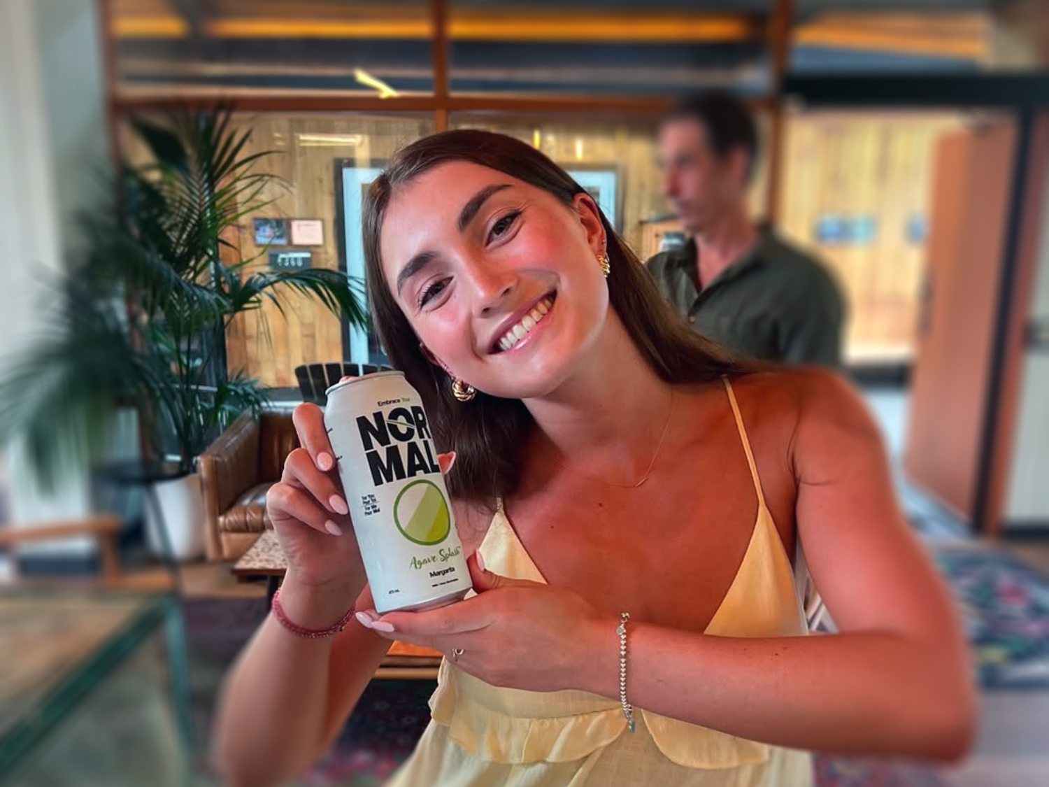 Agave Splash Margarita, has officially landed at iSetta Café Bistro. A young female holds a Normal Beverage Agave Splash Margarita can