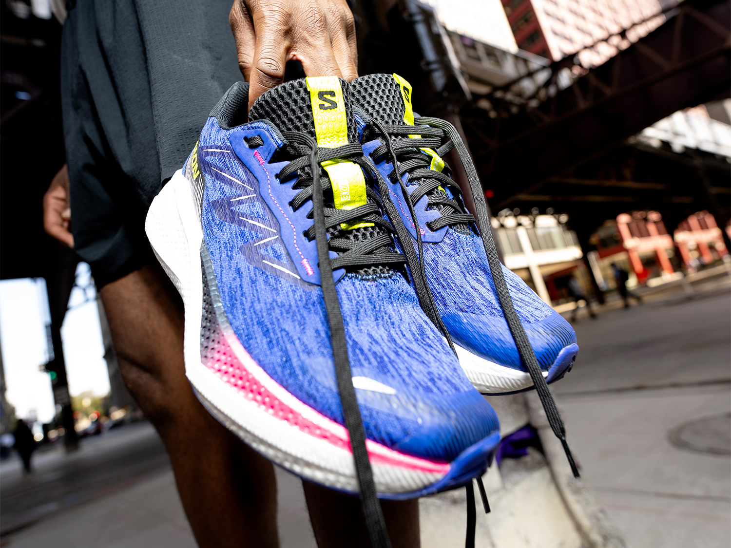 Man holding salomon Shoes in a city