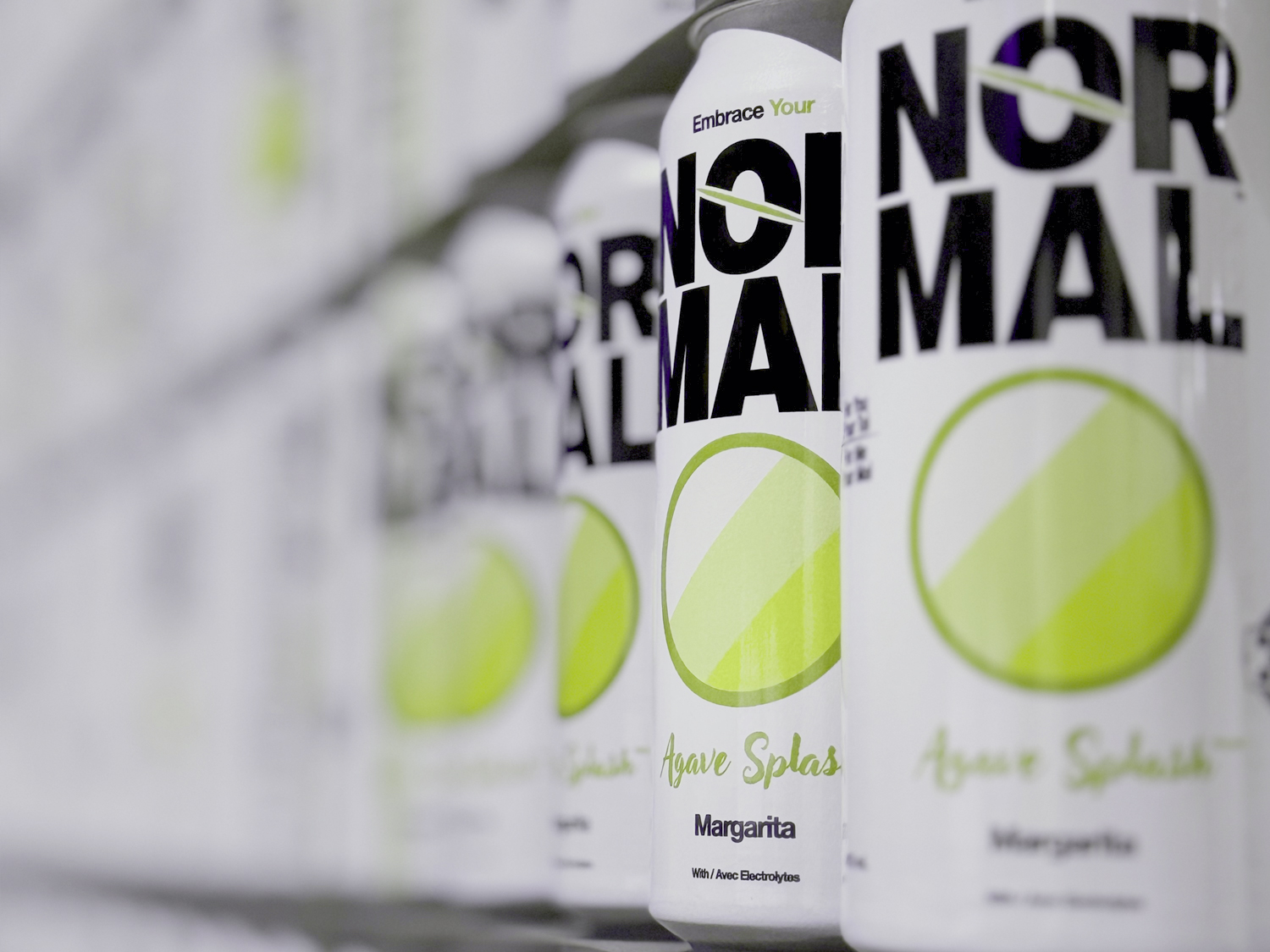 A low DOF image of many Normal Beverage Agave Splash Margarita cans on a pallet